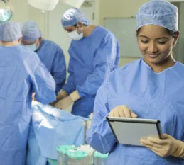 A team of surgeons doing surgery in modern operating room with various medical equipment & monitor