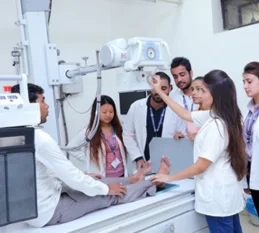 A diverse group surrounding a medical machine, possibly discussing its functionality and purpose.