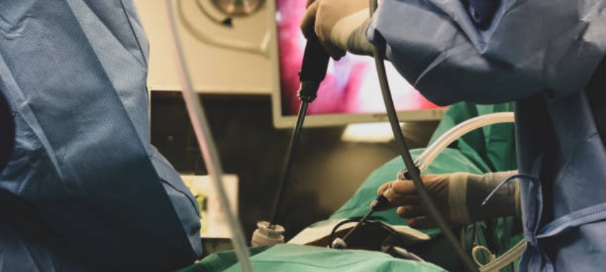 A surgeon focused during surgery, meticulously operating on a patient, with medical tools & machines