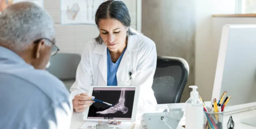 A doctor and patient analyzing an X-ray image, discussing medical findings and treatment options.