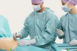 A team of surgeons in protective attire performing a cancer treatment operation.