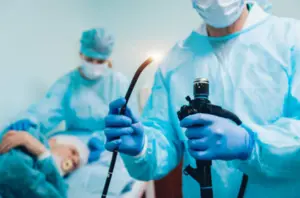 A focused surgeon uses medical equipment & machinery to carefully operate on patient during surgery
