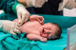 A doctor carefully examines a newborn baby during childbirth
