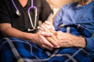 A kind nurse holding the hand of a patient in need of care, offering consolation and assistance.