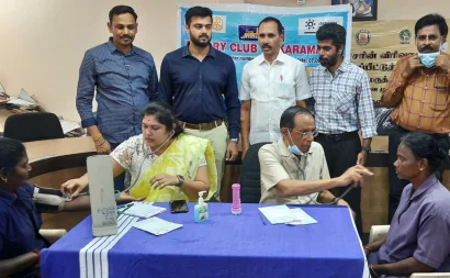 Two female patients are being examined by two doctors in a free medical camp for sanitation workers.
